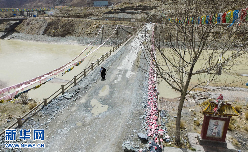 4月22日，尼瑪才讓老人通天河大橋上行走。新華社 吳剛 攝