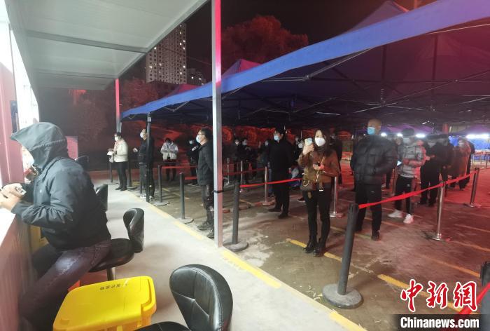 圖為核酸采集窗口前排隊(duì)等候的市民。　潘雨潔 攝