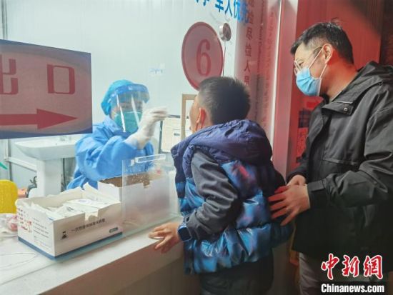 圖為家長帶著孩子進行核酸檢測采樣。 潘雨潔 攝 圖為家長帶著孩子進行核酸檢測采樣。 潘雨潔 攝